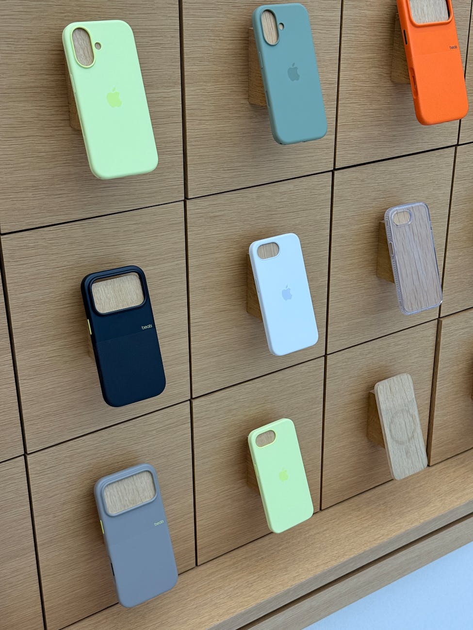 colorful phone cases displayed on wooden wall