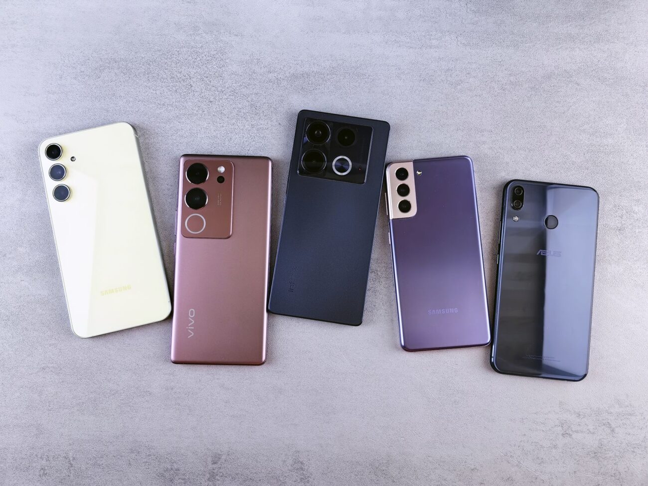 five smartphones on a gray background